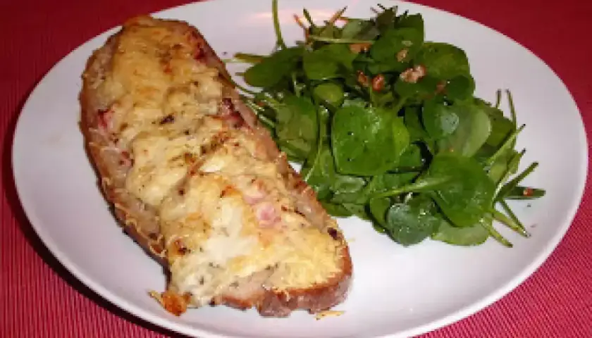 Tartine campagnarde au four, gratinée et dorée, servie avec une salade verte fraîche. Un délice simple et savoureux.