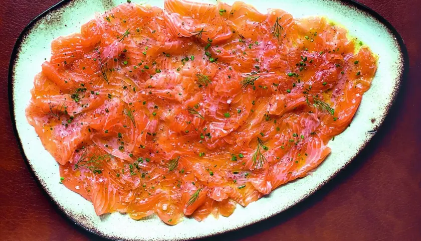 Délicieux carpaccio de saumon finement tranché, parsemé d'aneth frais et de ciboulette ciselée. Un plat léger et savoureux.