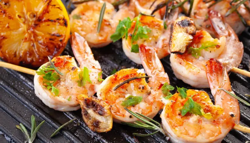 Crevettes grillées sur plancha, citron rôti et herbes fraîches. Une recette plancha conviviale parfaite pour partager.