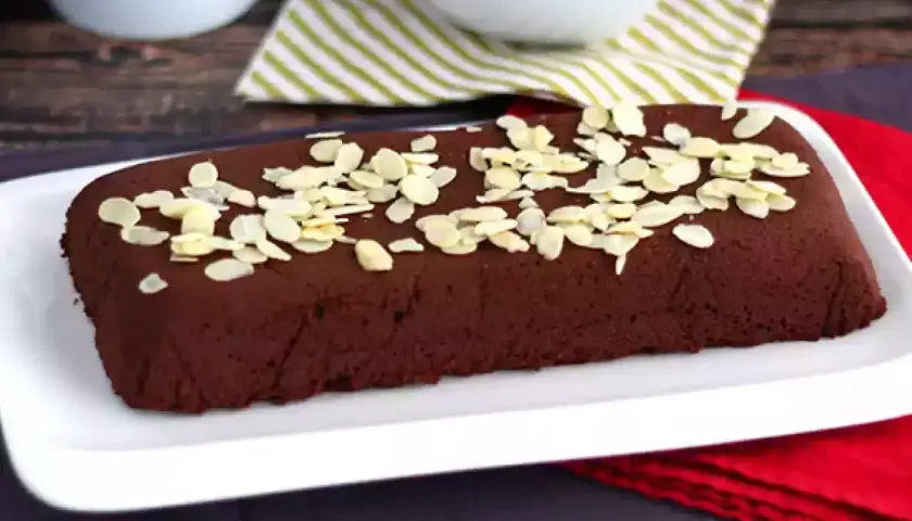 Une délicieuse marquise au chocolat, parsemée d'amandes effilées, prête à être dégustée.