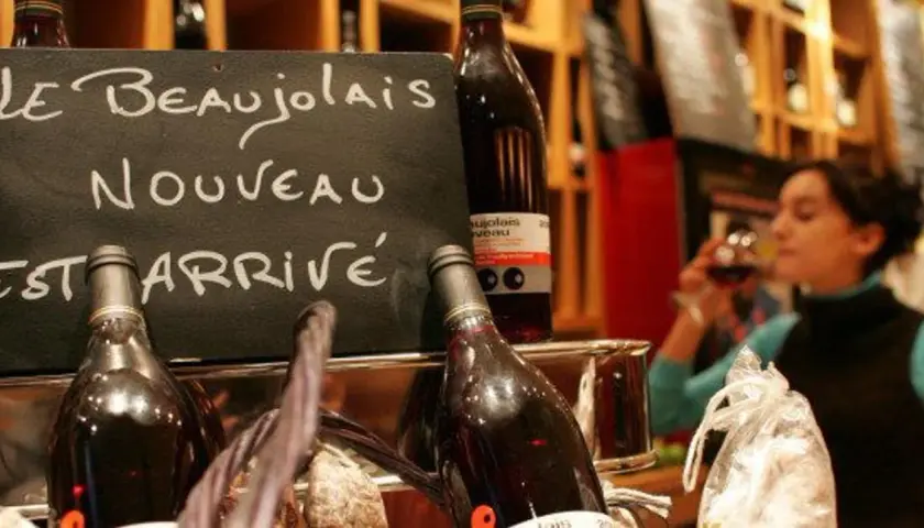 Le Beaujolais Nouveau est arrivé ! Une femme déguste ce vin jeune, symbole de la conservation des traditions viticoles.