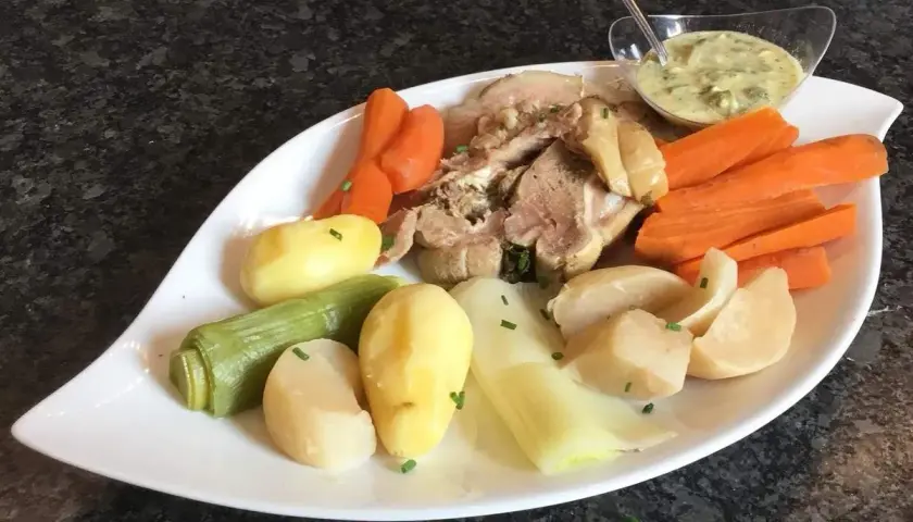 Tête de veau savoureuse accompagnée de carottes, pommes de terre et poireaux, le tout nappé d'une sauce crémeuse.