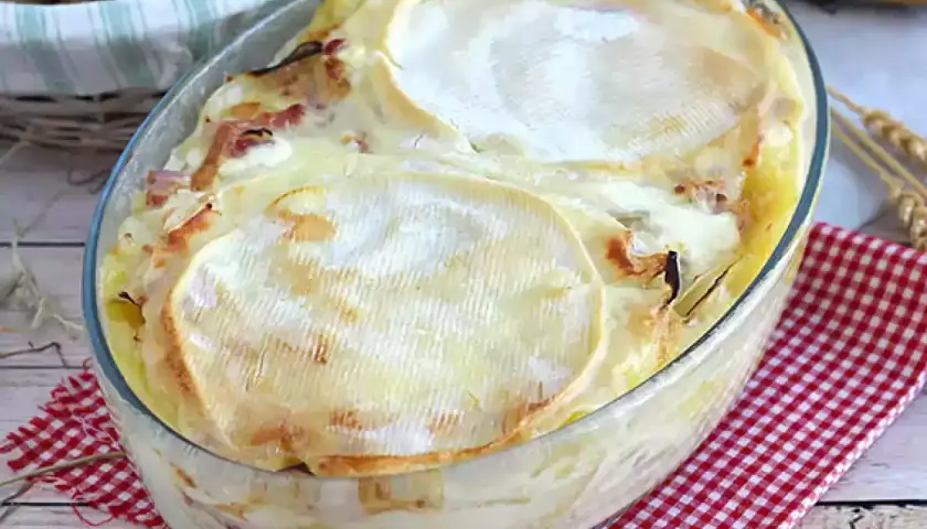 Un plat de tartiflette traditionnelle gratinée, avec son fromage fondant et ses lardons, prêt à être dégusté.