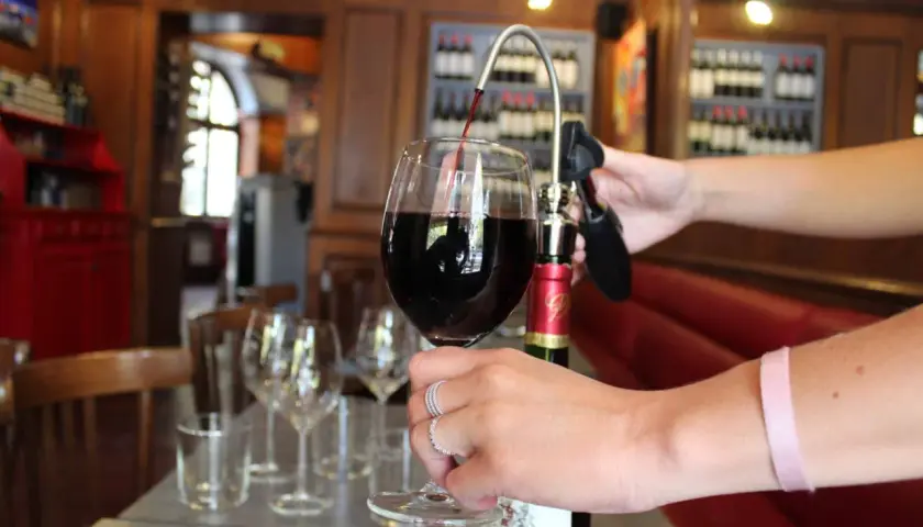 Service d'un vin rouge ouvert avec un tire-bouchon à pompe. La conservation du vin est assurée.