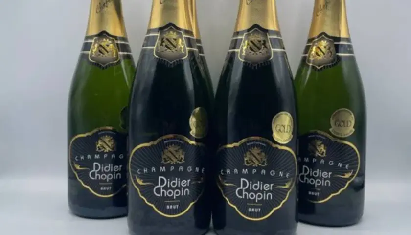 Quatre bouteilles de champagne Didier Chopin Brut, deux en verre sombre et deux en verre vert, avec leurs étiquettes noires et dorées. Un avis sur champagne Didier Chopin.