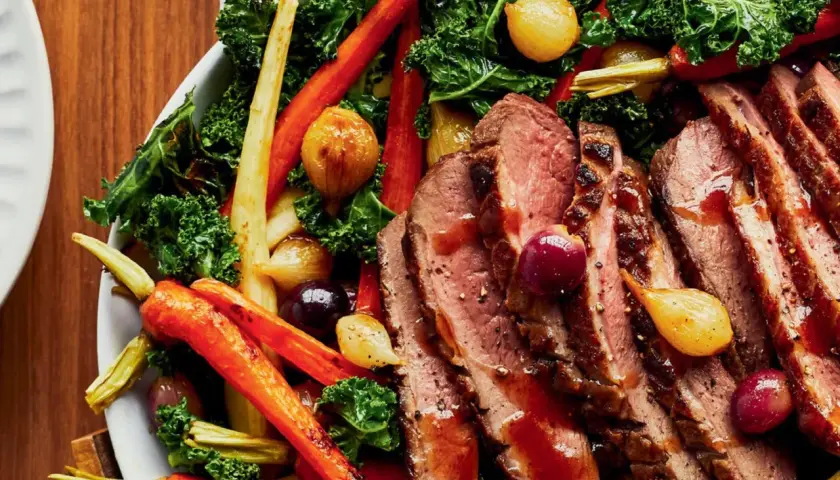Tranches de magret de canard aux 3 légumes rôtis : carottes, oignons grelots et chou kale. Un plat savoureux et coloré.