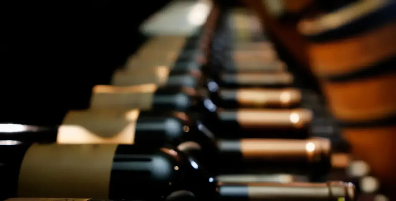 Des bouteilles de vin de garde alignées dans une cave sombre, attendant patiemment de révéler leurs arômes complexes.