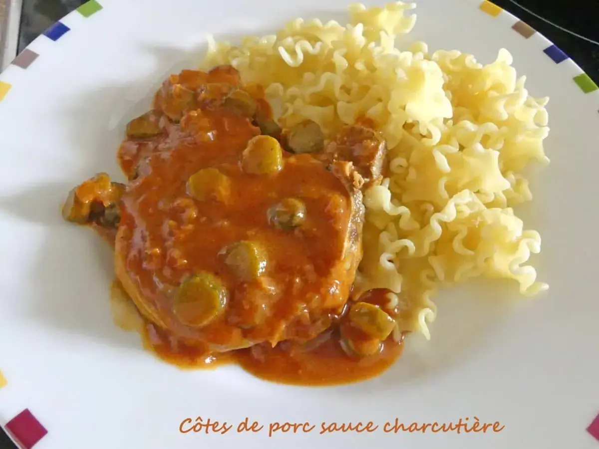 Côtes de porc sauce charcutière, un plat savoureux avec des pâtes frisées.