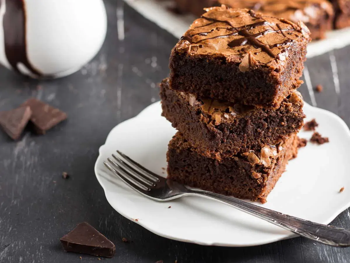 Pile de gâteaux au chocolat sur une assiette blanche avec une fourchette.