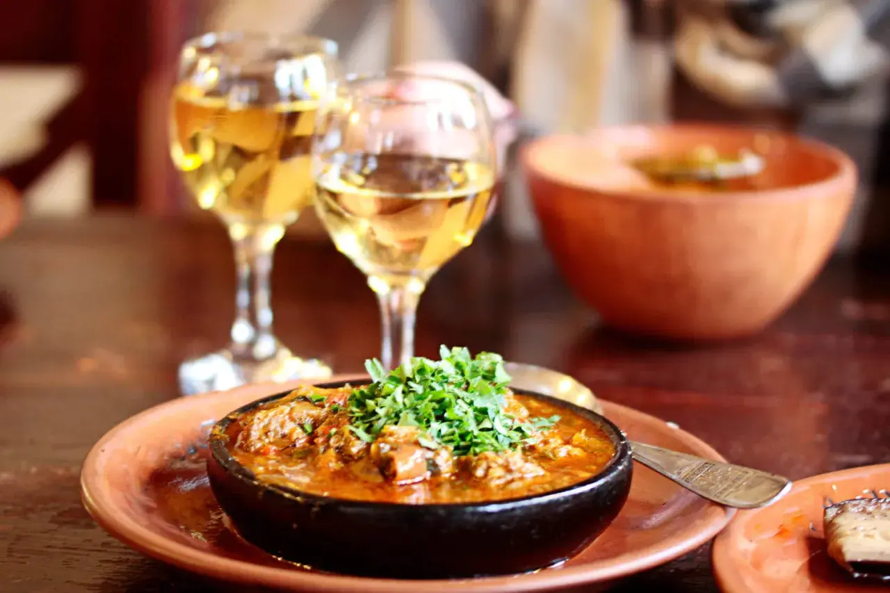 Un plat épicé de chili con carne, garni de persil frais, accompagné de deux verres de vin blanc. Quel vin blanc avec chili con carne ?