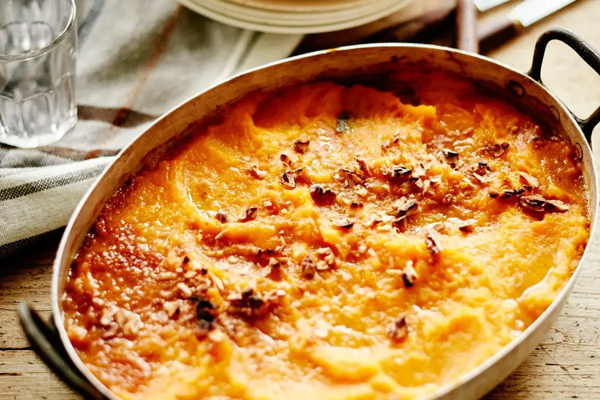 Hachis Parmentier gratiné, doré et parsemé de noix dans un plat ovale.