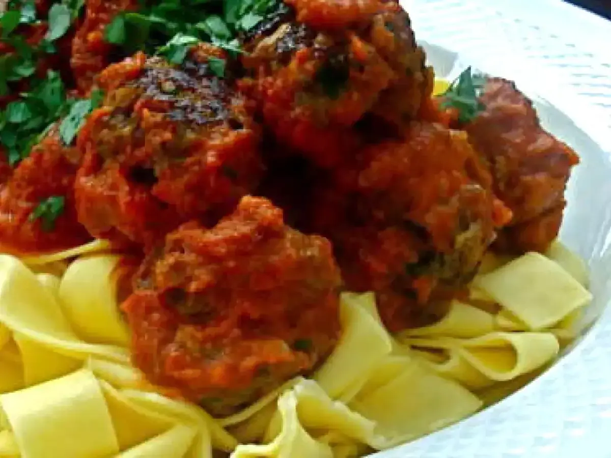 Boulettes de viande italienne savoureuses en sauce tomate, servies sur des pâtes fraîches. Une recette parfaite pour un repas réconfortant.