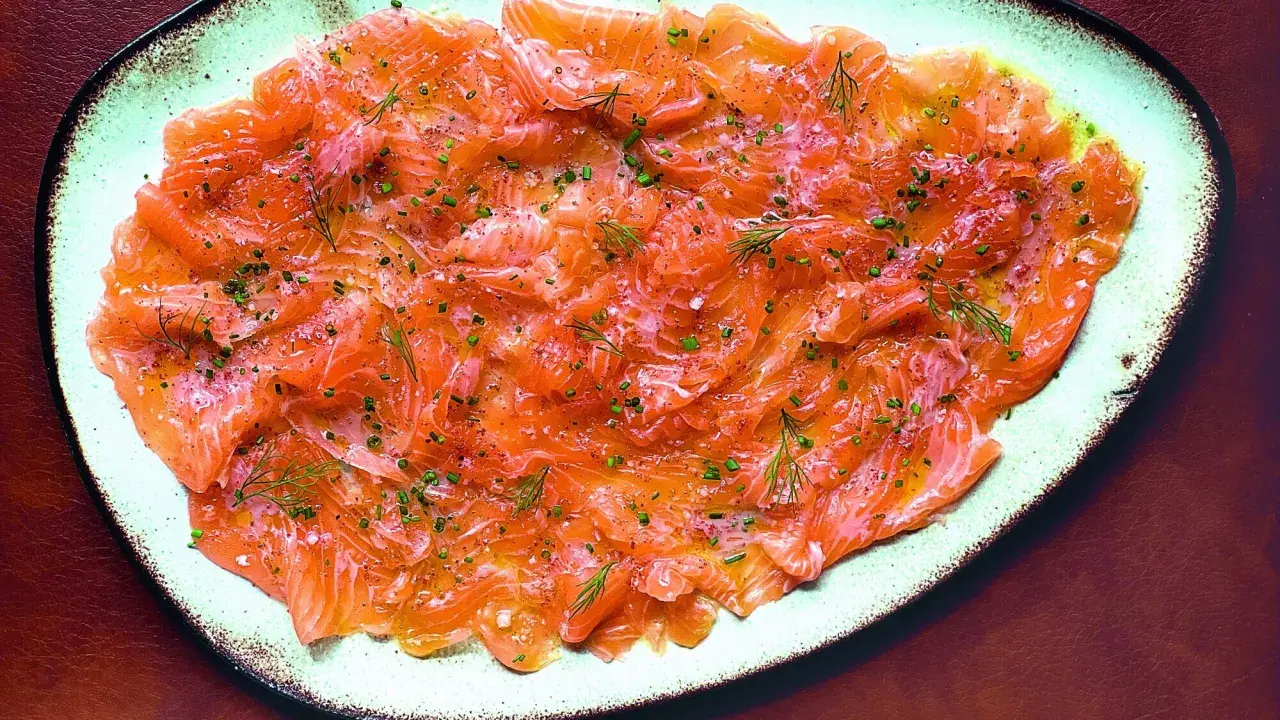 Délicieux carpaccio de saumon finement tranché, parsemé d'aneth frais et de ciboulette ciselée. Un plat léger et savoureux.