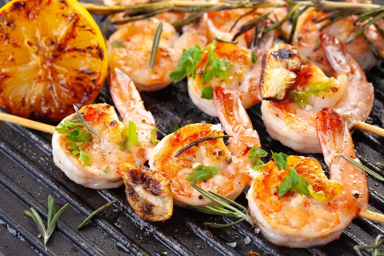 Crevettes grillées sur plancha, citron rôti et herbes fraîches. Une recette plancha conviviale parfaite pour partager.