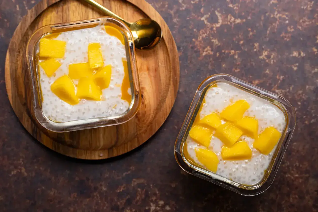 Deux coupelles de tapioca au lait de coco, garnies de dés de mangue fraîche. Un délice tropical.