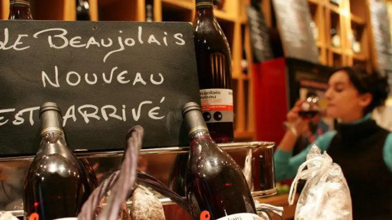 Le Beaujolais Nouveau est arrivé ! Une femme déguste ce vin jeune, symbole de la conservation des traditions viticoles.