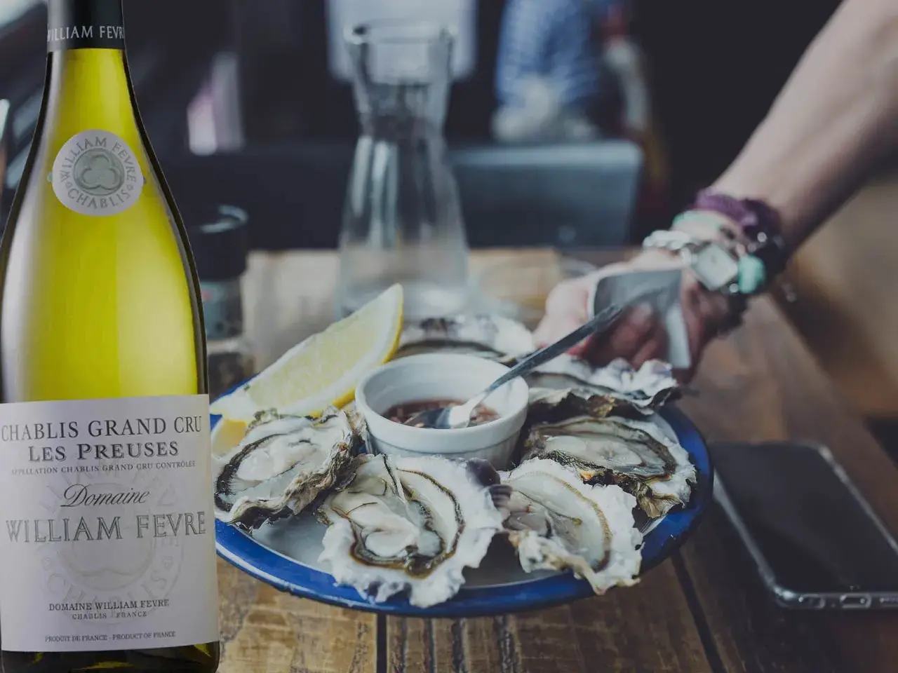 Bouteille de Chablis Grand Cru William Fèvre à côté d'huîtres fraîches. Le parfait accord pour savoir quel vin avec les huîtres.