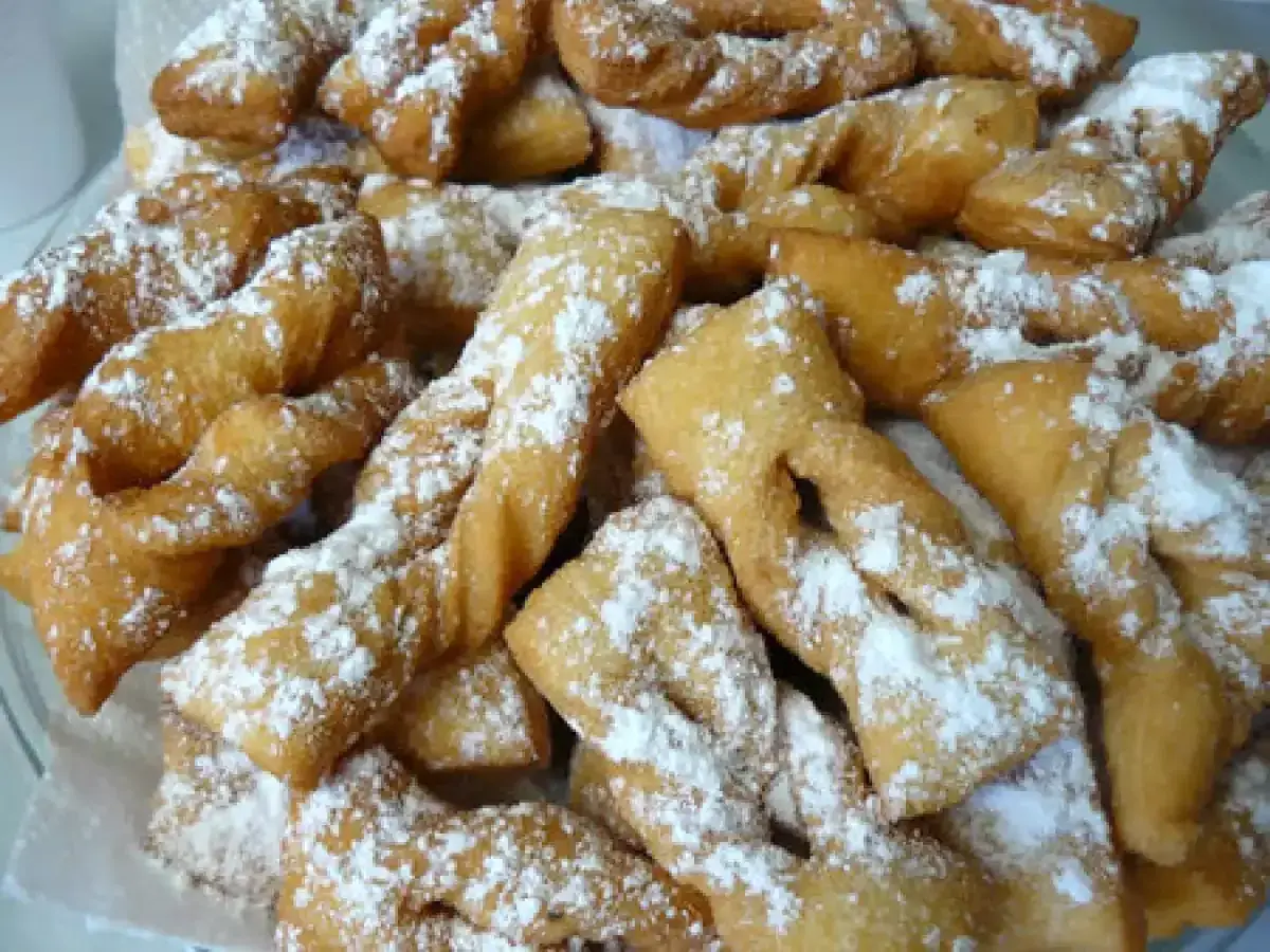 Une assiette généreuse de bugnes lyonnaises dorées, saupoudrées de sucre glace. La meilleure recette de bugnes lyonnaises pour un goûter gourmand.