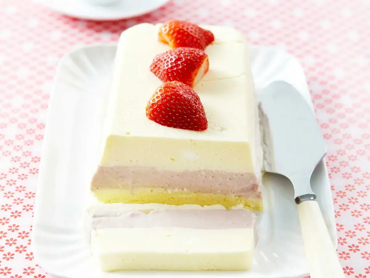 Un délicieux parfait glacé aux fraises, aux couches de crème et de biscuit, prêt à être dégusté.