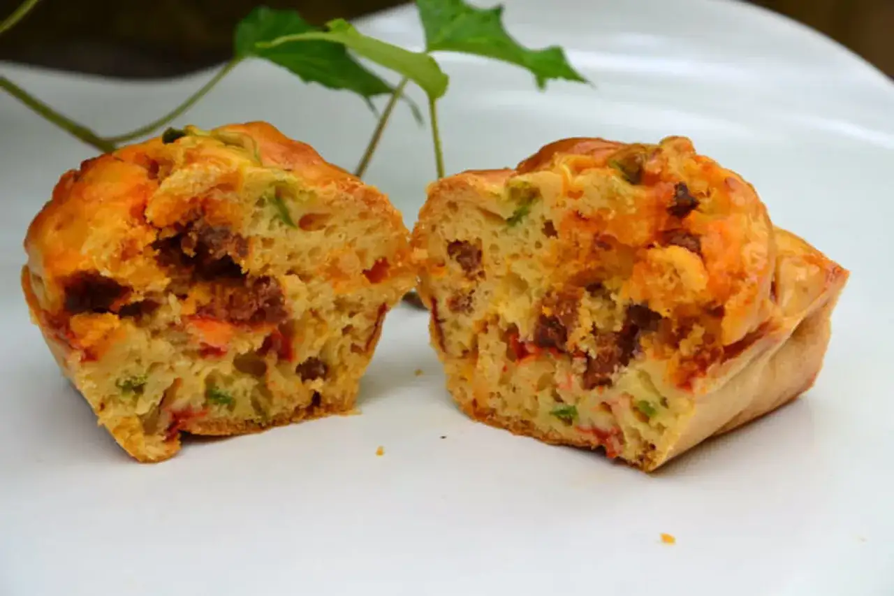 Un cake salé coupé en deux, révélant des morceaux de chorizo et de poivron dans une pâte dorée.
