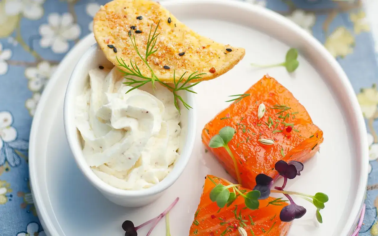 Délicieux saumon gravlax recette, servi avec une crème onctueuse et une chips croustillante.