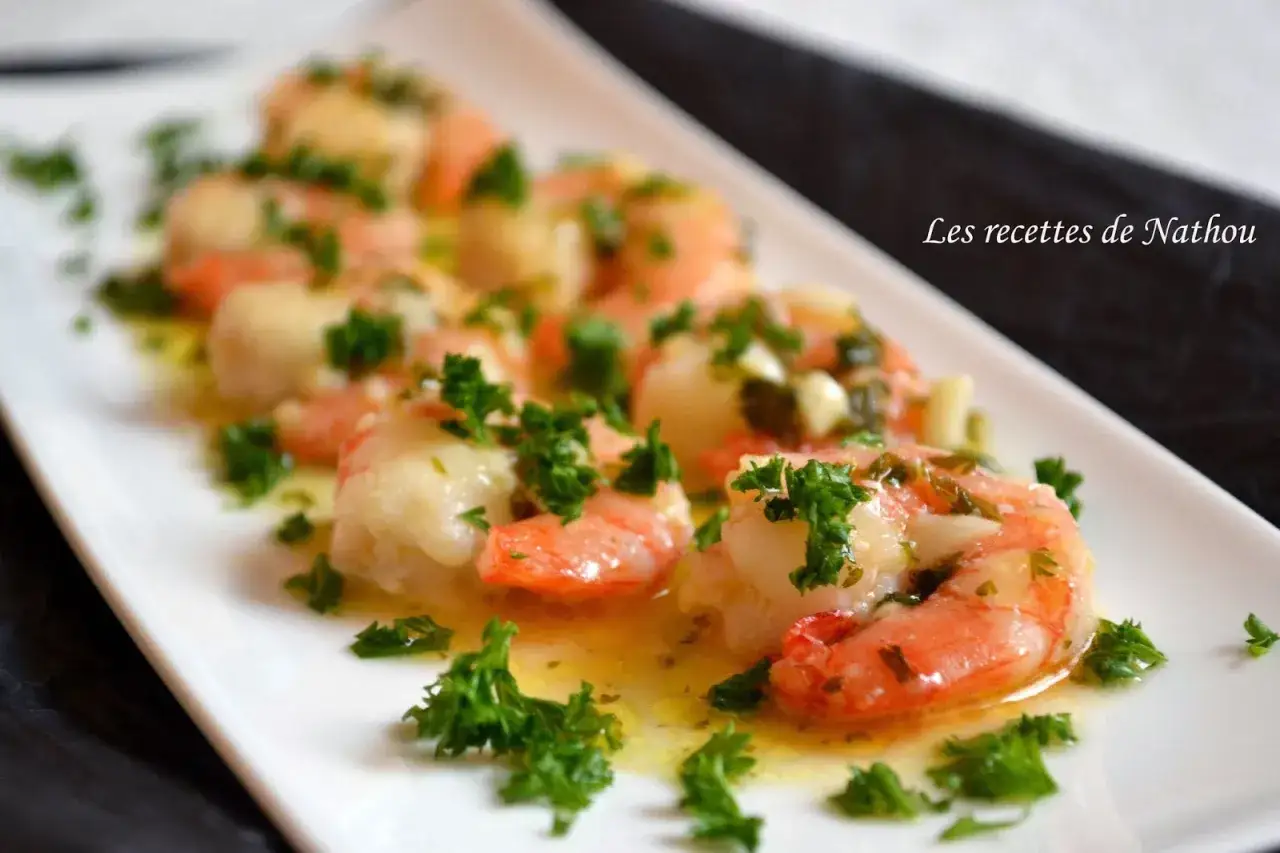 Gambas barbecue nappées d'une sauce à l'ail et persil, servies sur une assiette blanche.