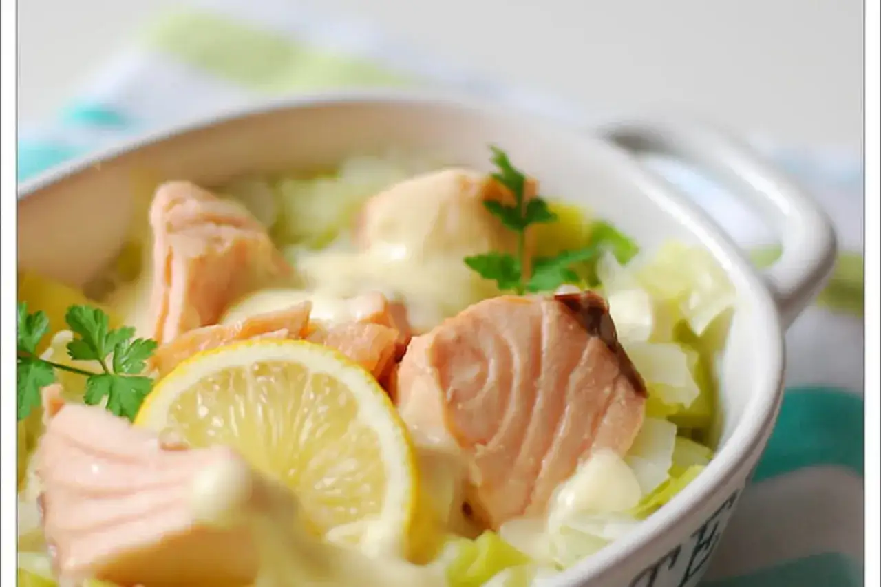 Blanquette de saumon avec sauce crémeuse, citron et persil dans un bol blanc.