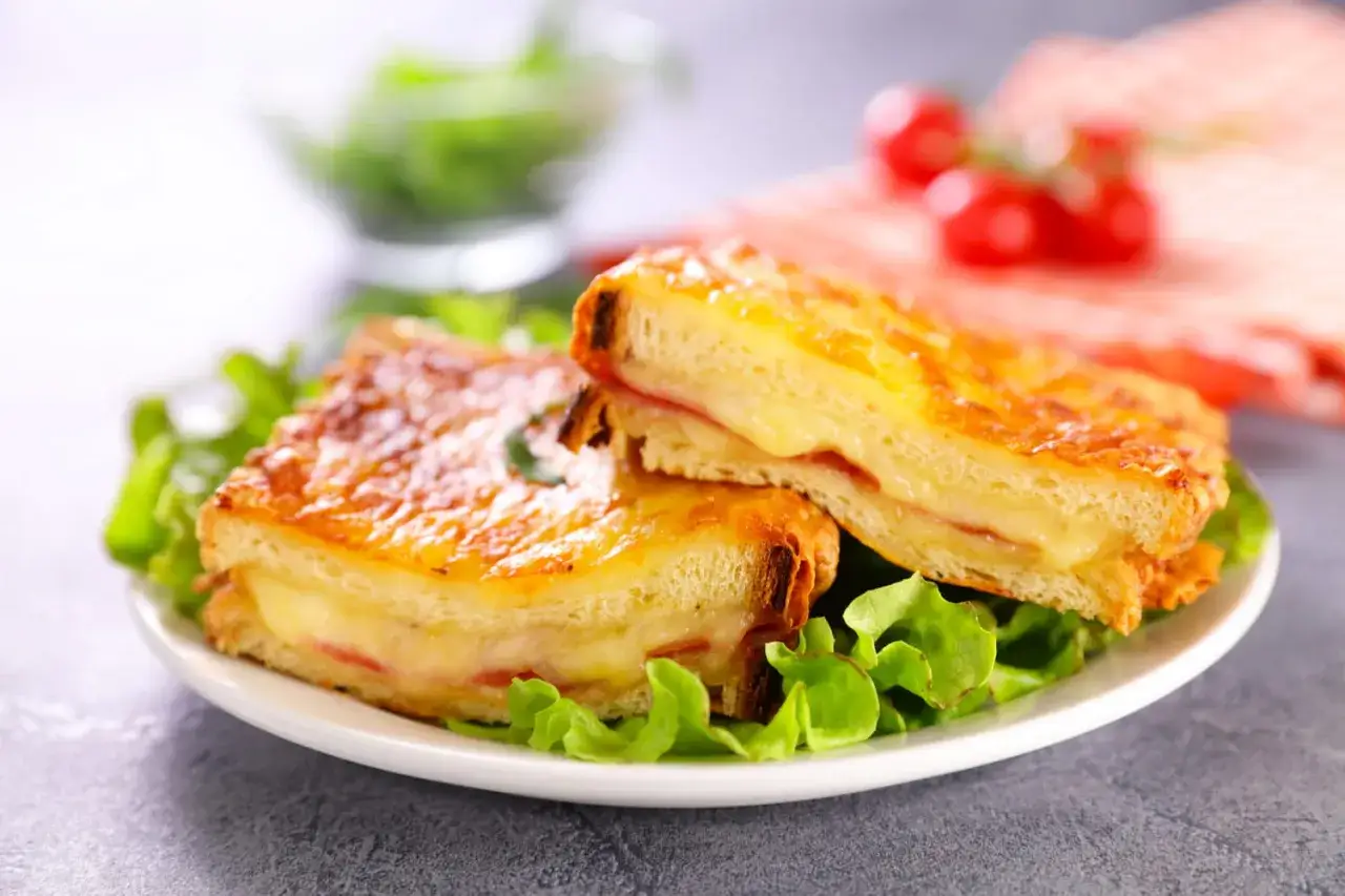 Deux délicieux croque monsieur au four, dorés et fondants, servis sur un lit de salade verte.
