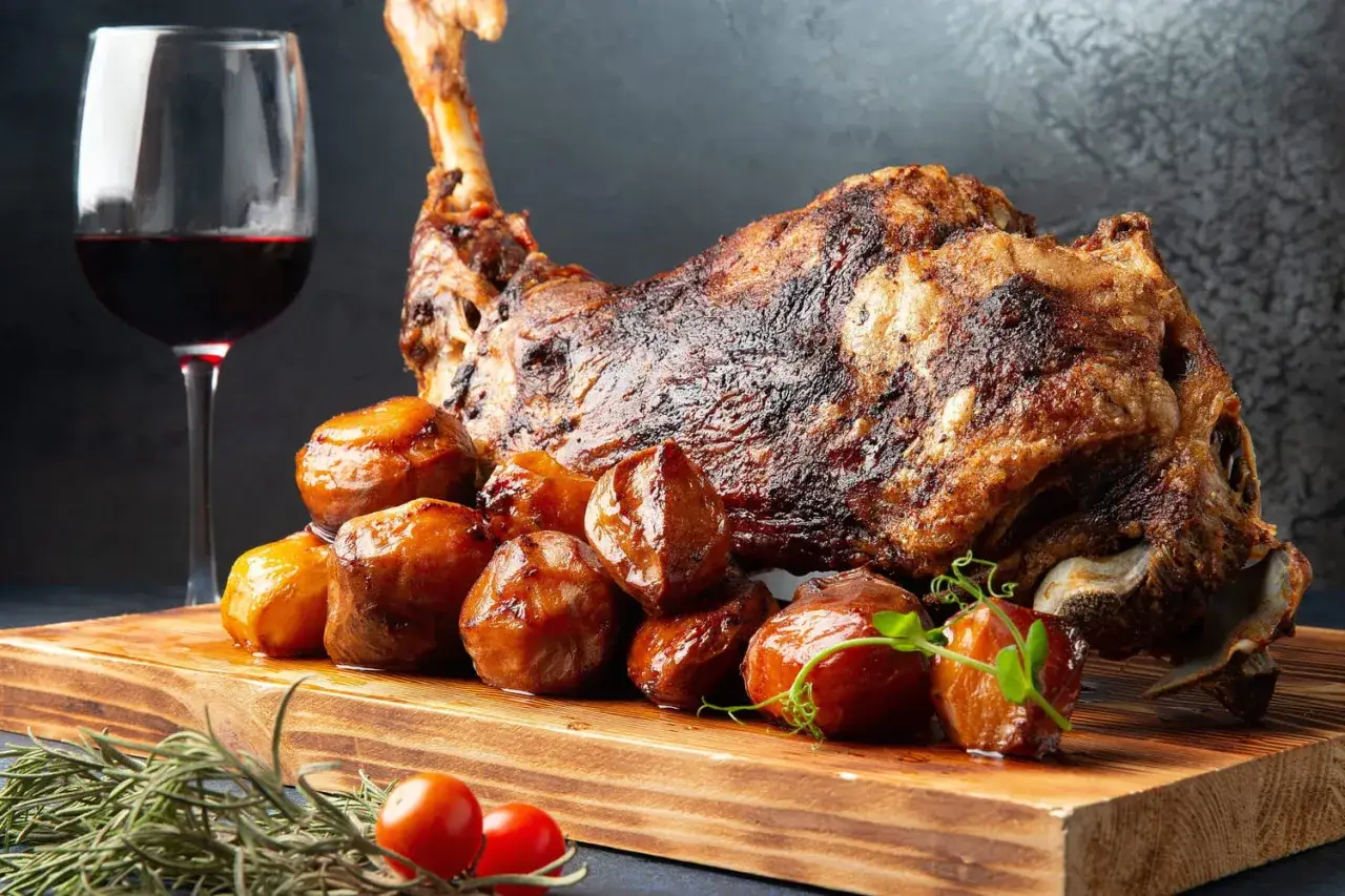 Gigot d'agneau rôti, pommes de terre et un verre de vin rouge. Parfait pour accompagner un gigot de 7 heures.