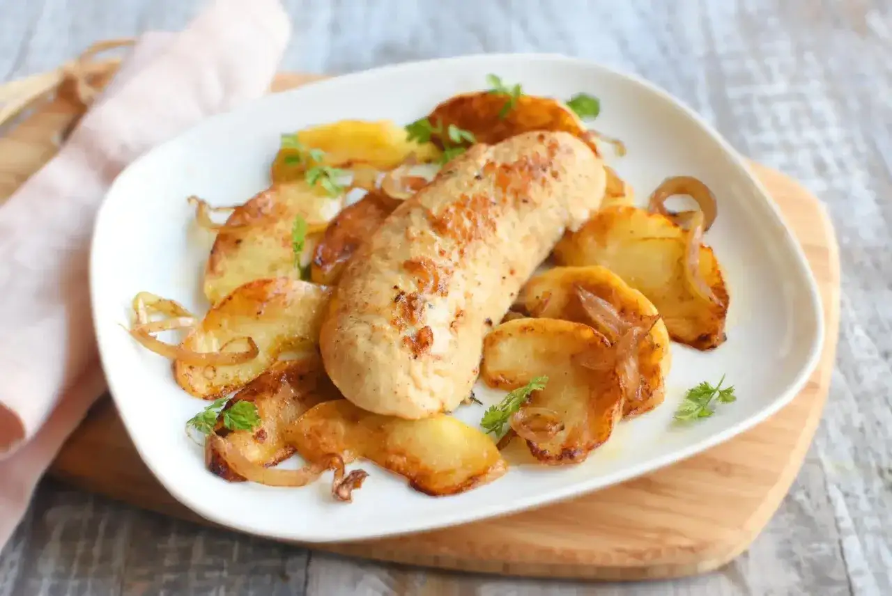 Un plat savoureux : quelle pomme avec boudin blanc, entouré de pommes de terre rôties et d'oignons caramélisés.
