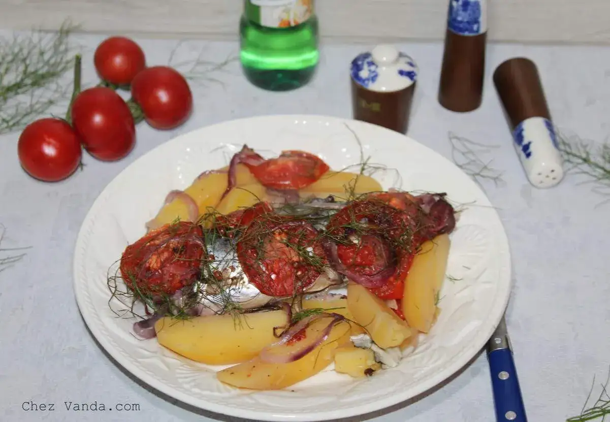 Assiette de maquereau au vin blanc, pommes de terre, tomates et oignons rouges, garnie d'aneth.