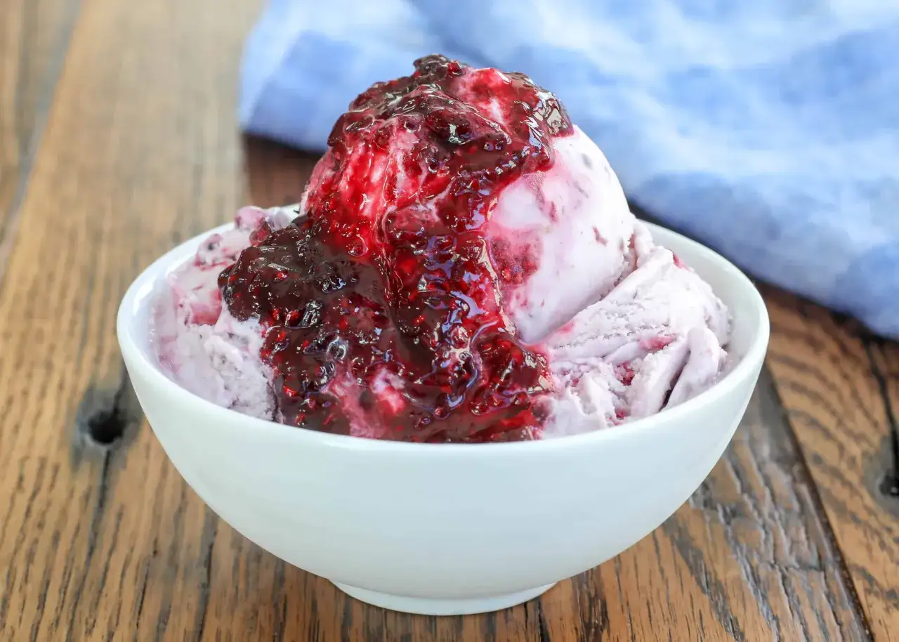 Une boule de glace &agrave; la vanille napp&eacute;e d'une compot&eacute;e de fruits rouges. Parfait avec quoi accompagner une boule de glace pour un dessert gourmand.