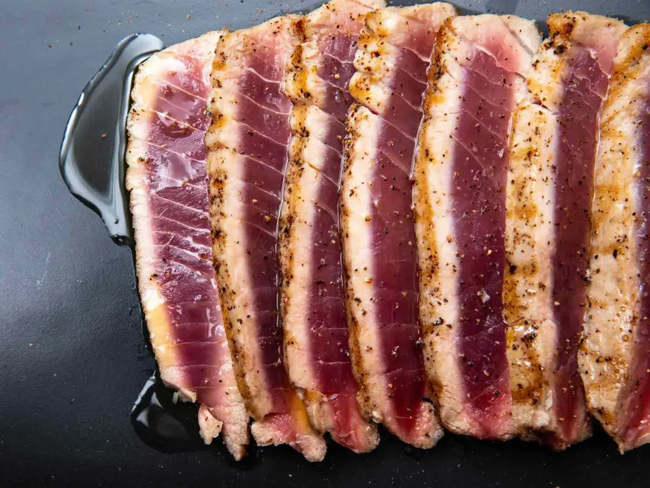 Tranches de thon au barbecue, poêlé à la perfection, avec une croûte poivrée et un cœur rosé. Un délice !