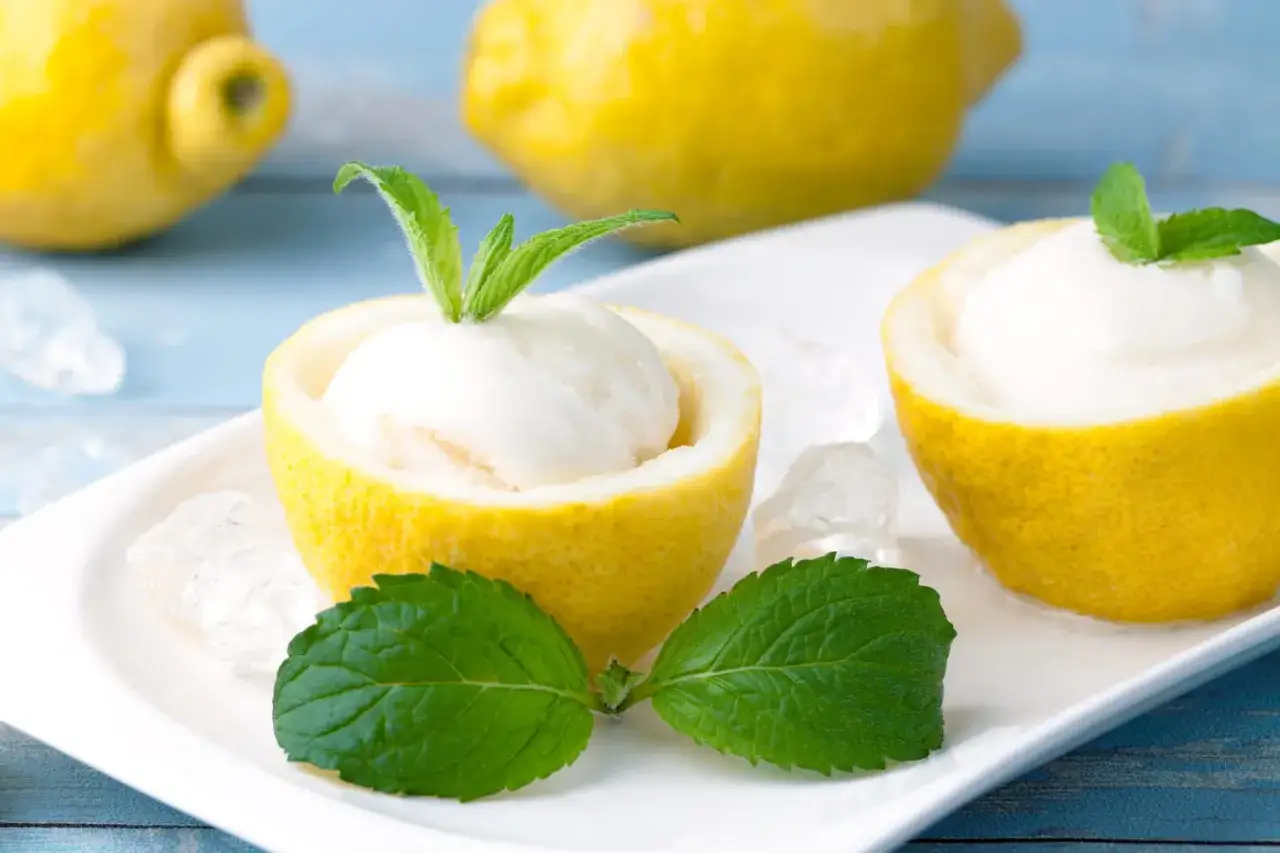 Deux citrons givrés servis dans leur propre écorce, garni de menthe fraîche et de glaçons. Un délice rafraîchissant !