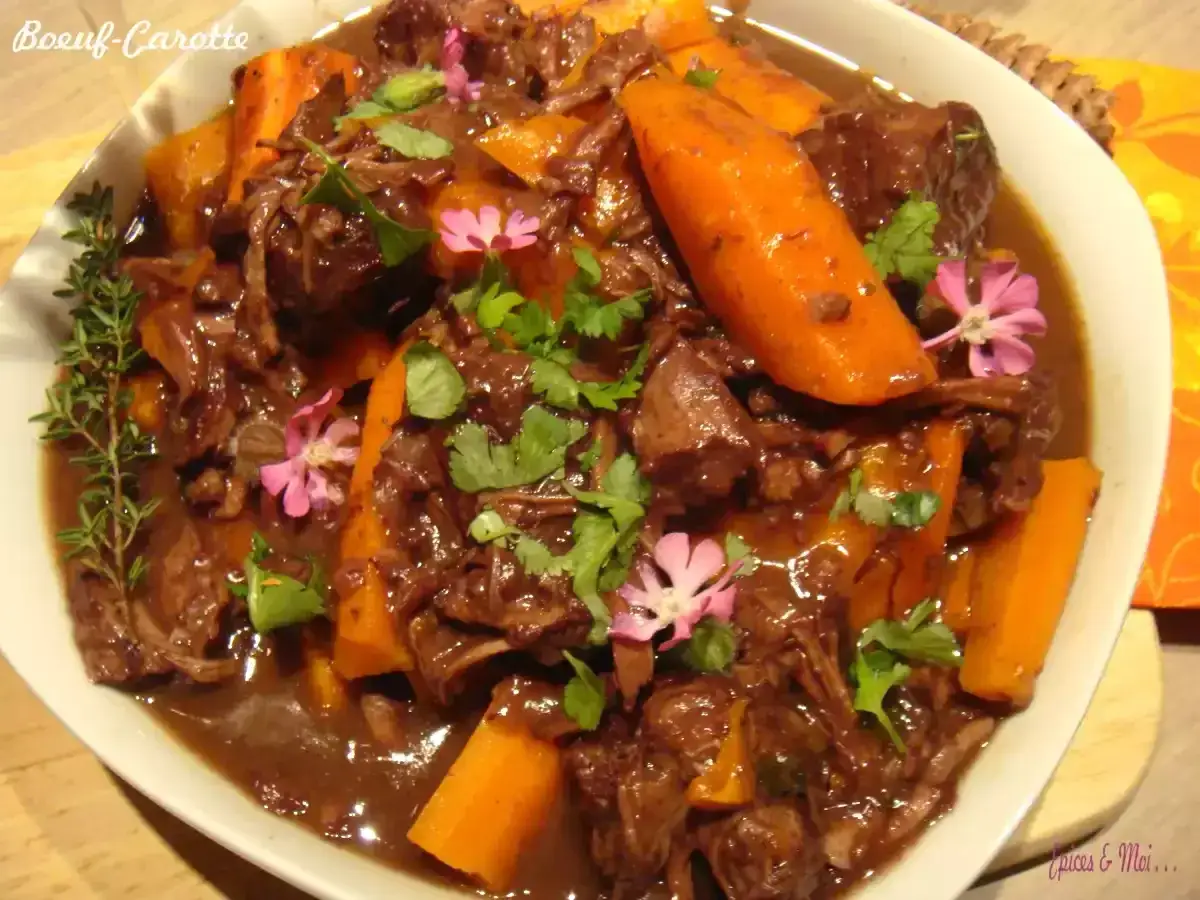 Un plat de bœuf carottes mijoté, garni de persil et de fleurs roses. Quel vin avec boeuf carottes ? Un vin rouge corsé serait parfait.