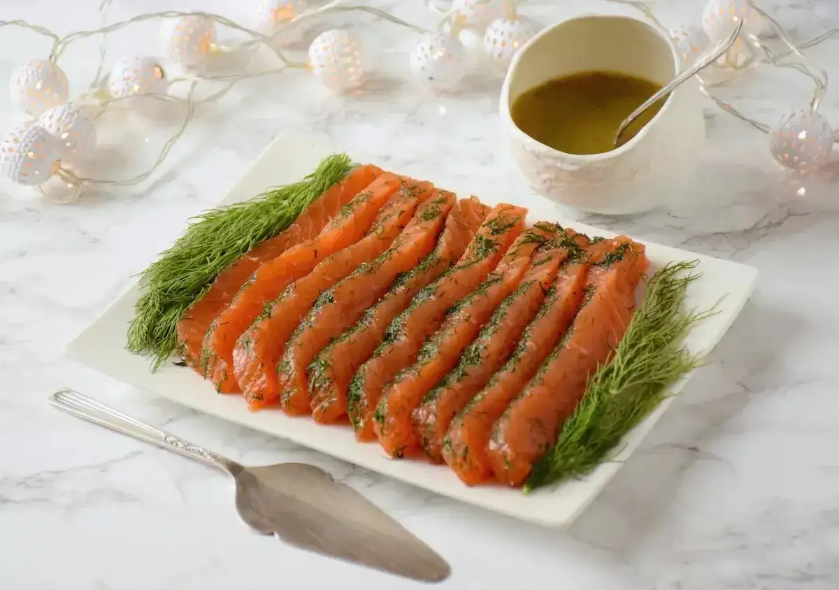 Un plateau de saumon gravlax, garni d'aneth, prêt à être dégusté. Quel vin avec saumon gravlax ? Un blanc sec ou un rosé léger serait parfait.