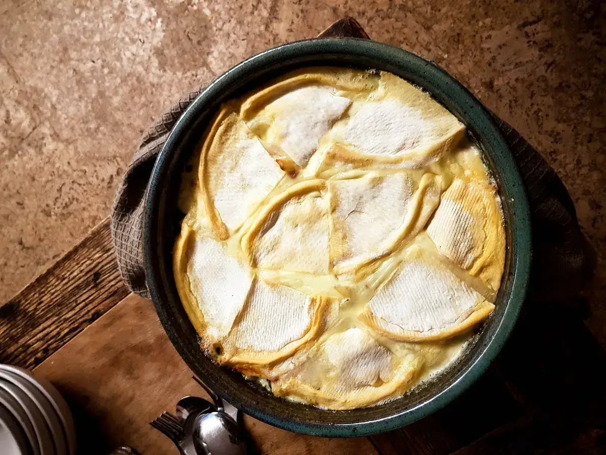 Une tartiflette traditionnelle dorée et gratinée, prête à être dégustée. Le fromage fondu et les pommes de terre invitent au partage.