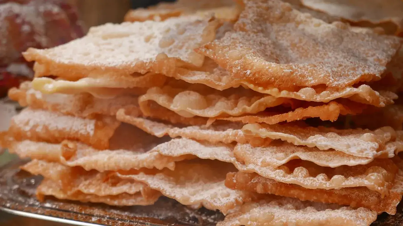 Pile de bugnes lyonnaises saupoudrées de sucre glace. La meilleure recette de bugnes lyonnaises pour un goûter gourmand.
