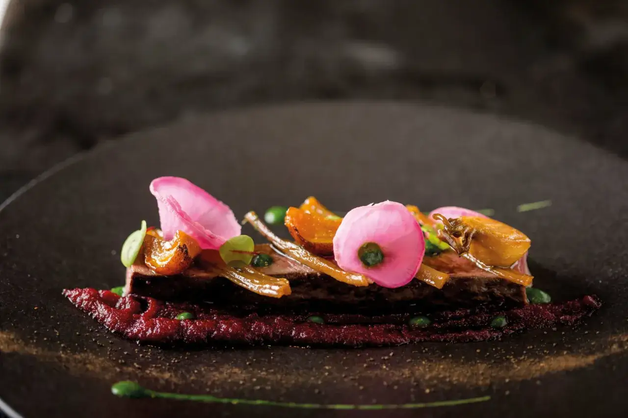 Plat de chevreuil avec purée de betterave, garni de radis roses et de fruits secs. Quel vin avec du chevreuil ? Un Pinot Noir serait parfait.