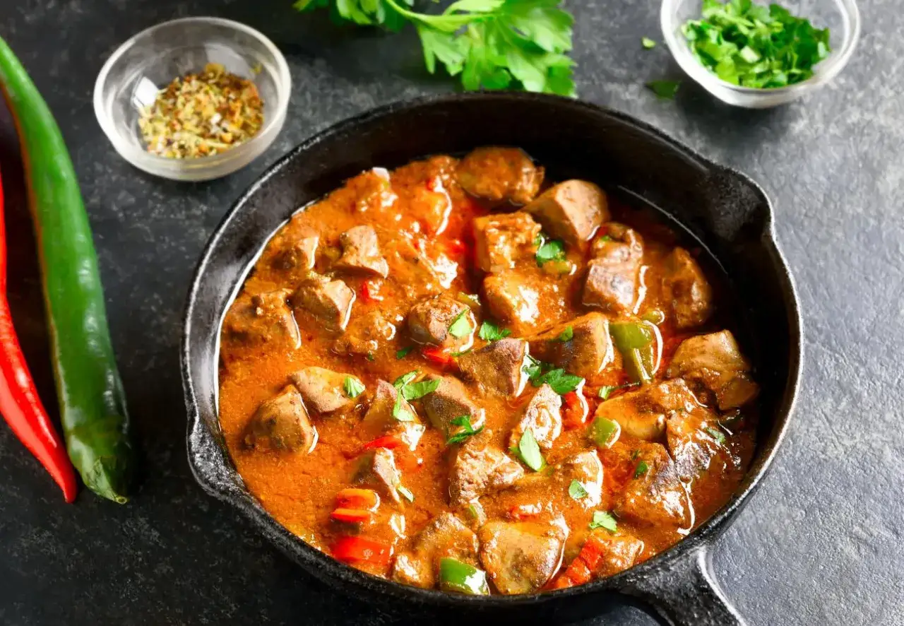 Poêlée de foie de volaille aux poivrons et épices, garnie de persil frais. Un plat savoureux et coloré.