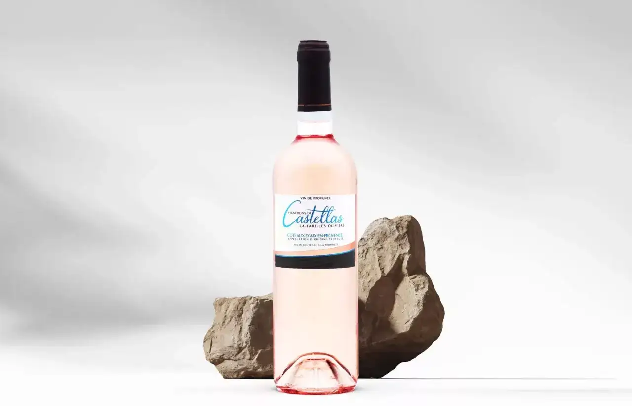Bouteille de vin rosé de Provence, Castellas, posée entre deux rochers. Un guide pour comment choisir un vin rosé.
