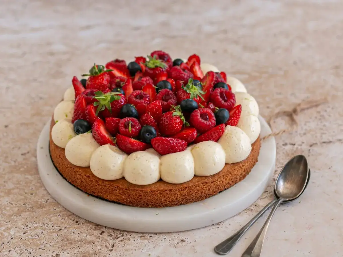 D&eacute;licieux g&acirc;teau aux fruits rouges sur une base de sable breton, garni de cr&egrave;me vanill&eacute;e et de fraises, framboises et myrtilles.