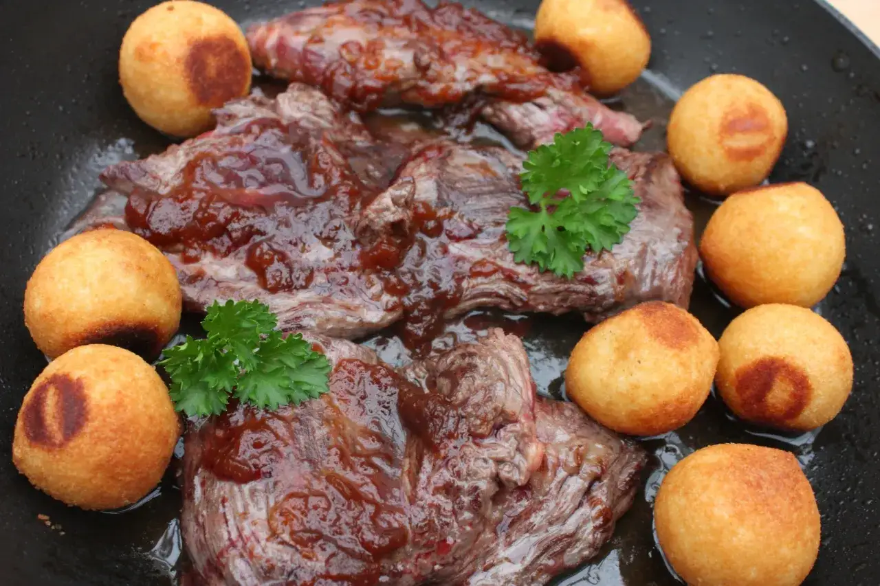 Délicieux onglet à l'échalote, servi avec des petites pommes de terre dorées et du persil frais. Un plat savoureux.