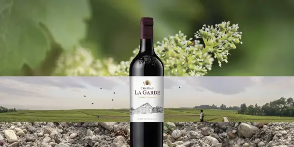 Bouteille de vin rouge Château La Garde, Pessac-Léognan. Paysage de vignes et de graviers.