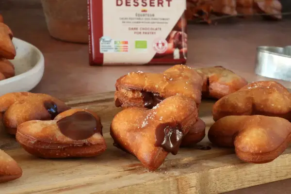 Des cœurs gourmands de beignet au chocolat, certains saupoudrés de sucre, d'autres généreusement garnis de chocolat fondant.